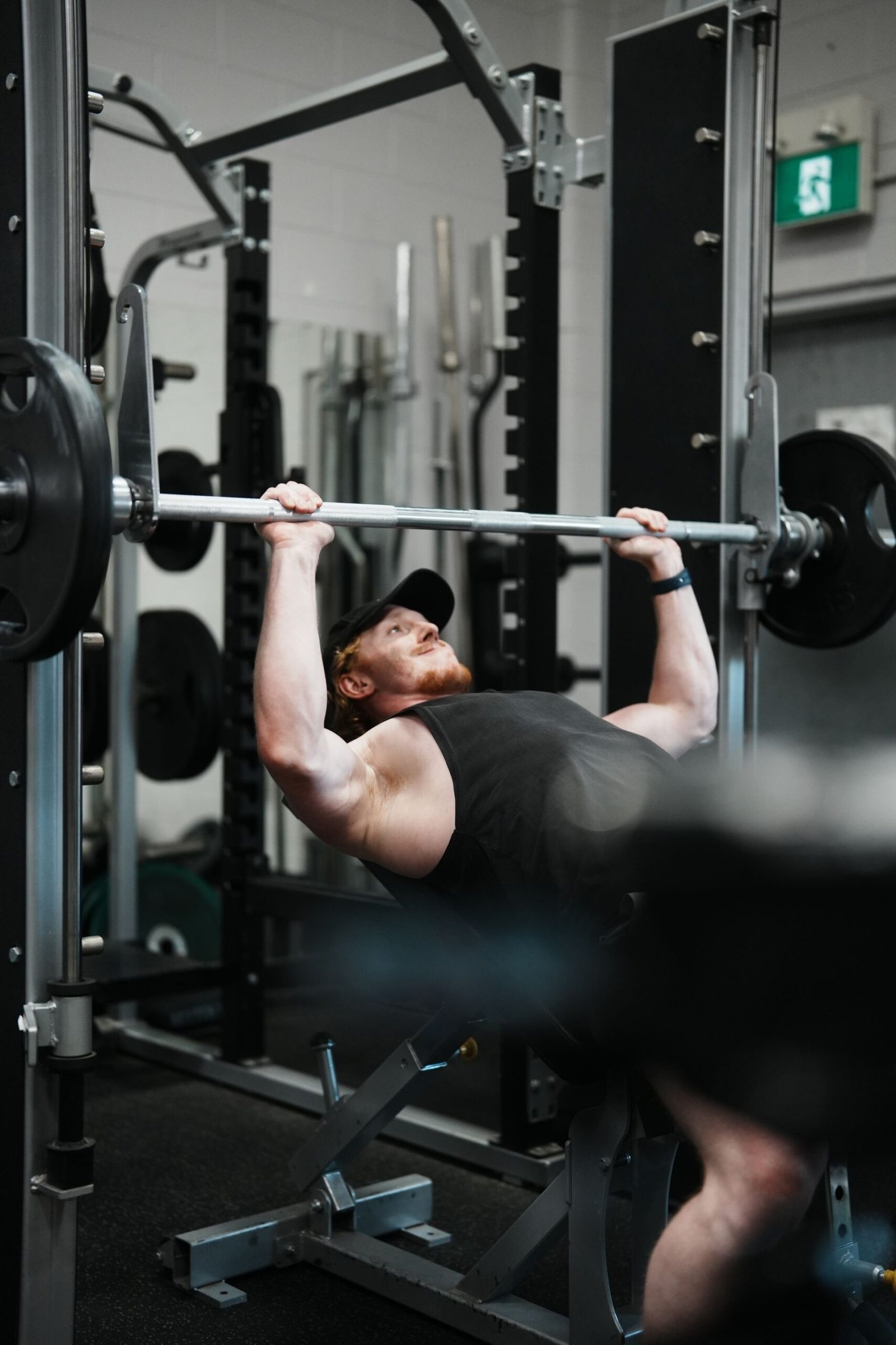 A man performing an incline bench press in a gym
