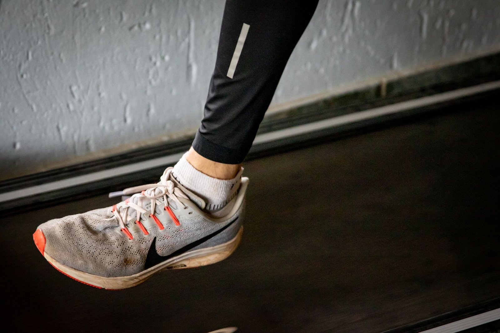 Close-up of a running shoe mid-stride on a treadmill belt