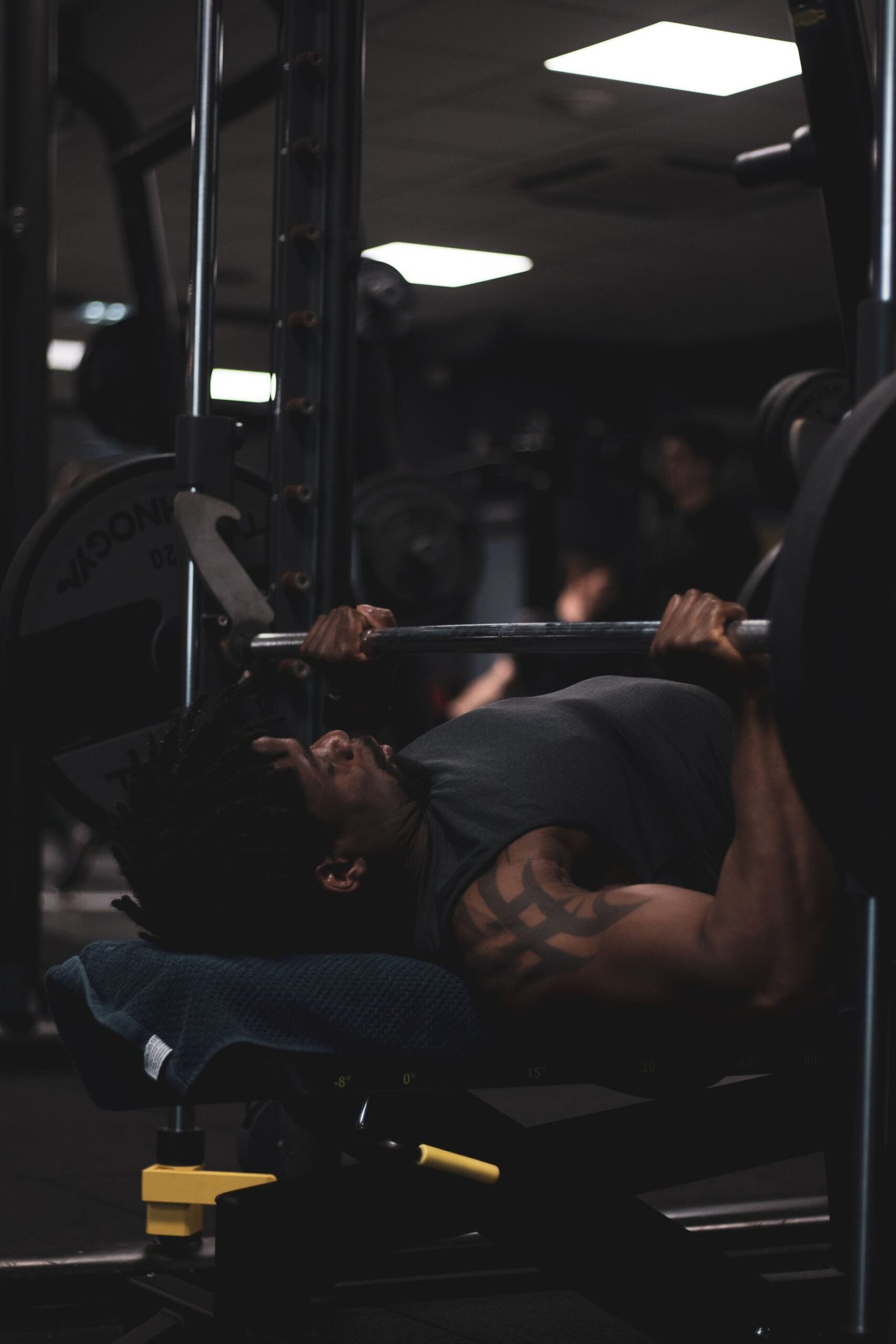 A man bench pressing in a dimly lit gym
